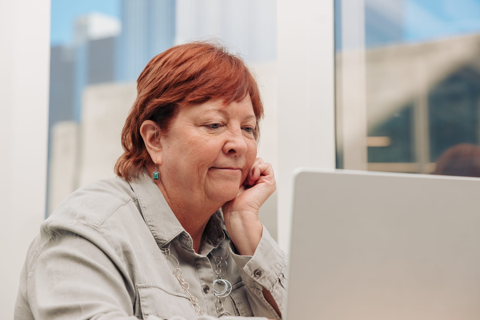 Deb working on her laptop, representing AI-powered information and accessibility services.